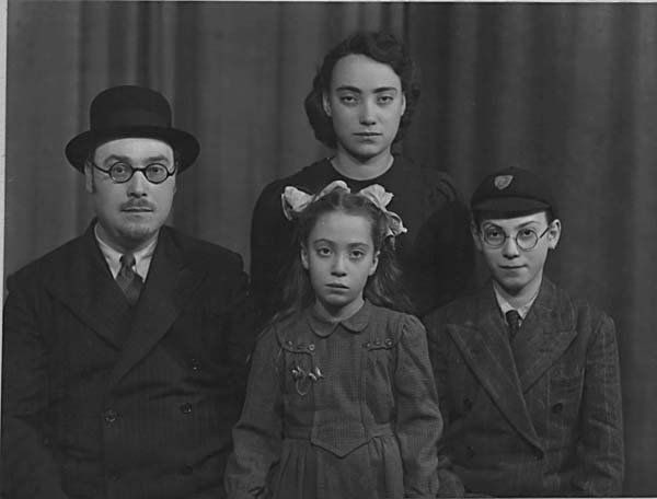 The surviving Nichtburg children and their father, March 25, 1948. This photo was taken a couple years after the family reunited in England. Jakob Nichtburg [far left] with Alice (Lici) [standing] and Ilse and David (Dudi) [sitting]. 